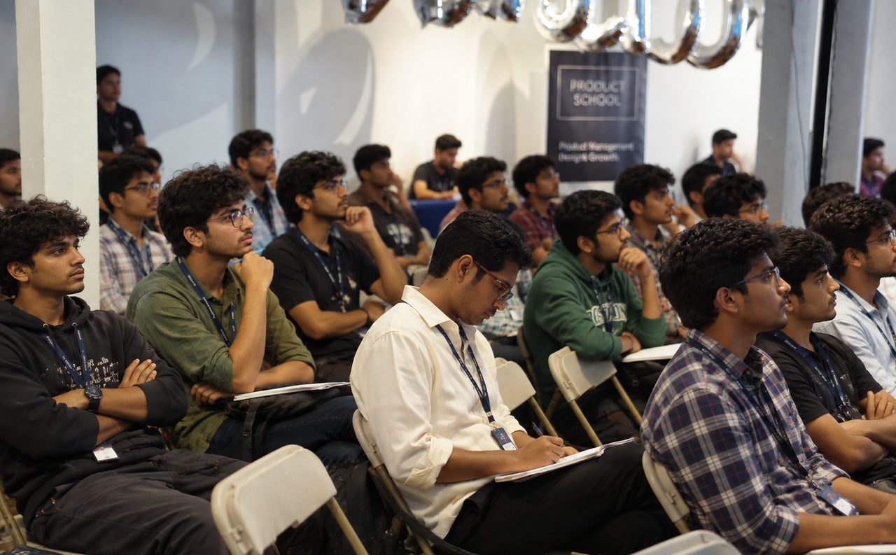 Rows of college students at a talk, listening and taking notes